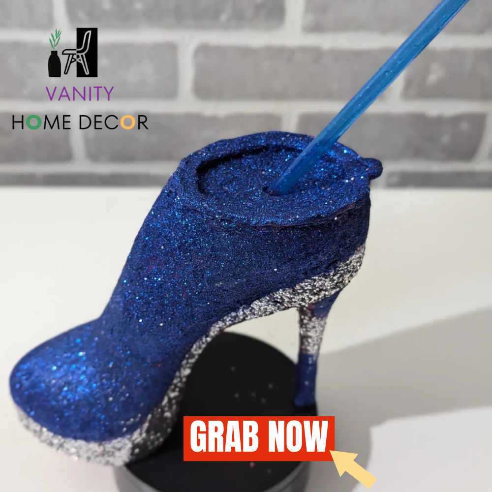 Decorative Blue Custom Stiletto Heel Tumbler Cup with a straw, branded 'Vanity Home Decor', on a gray brick wall background.