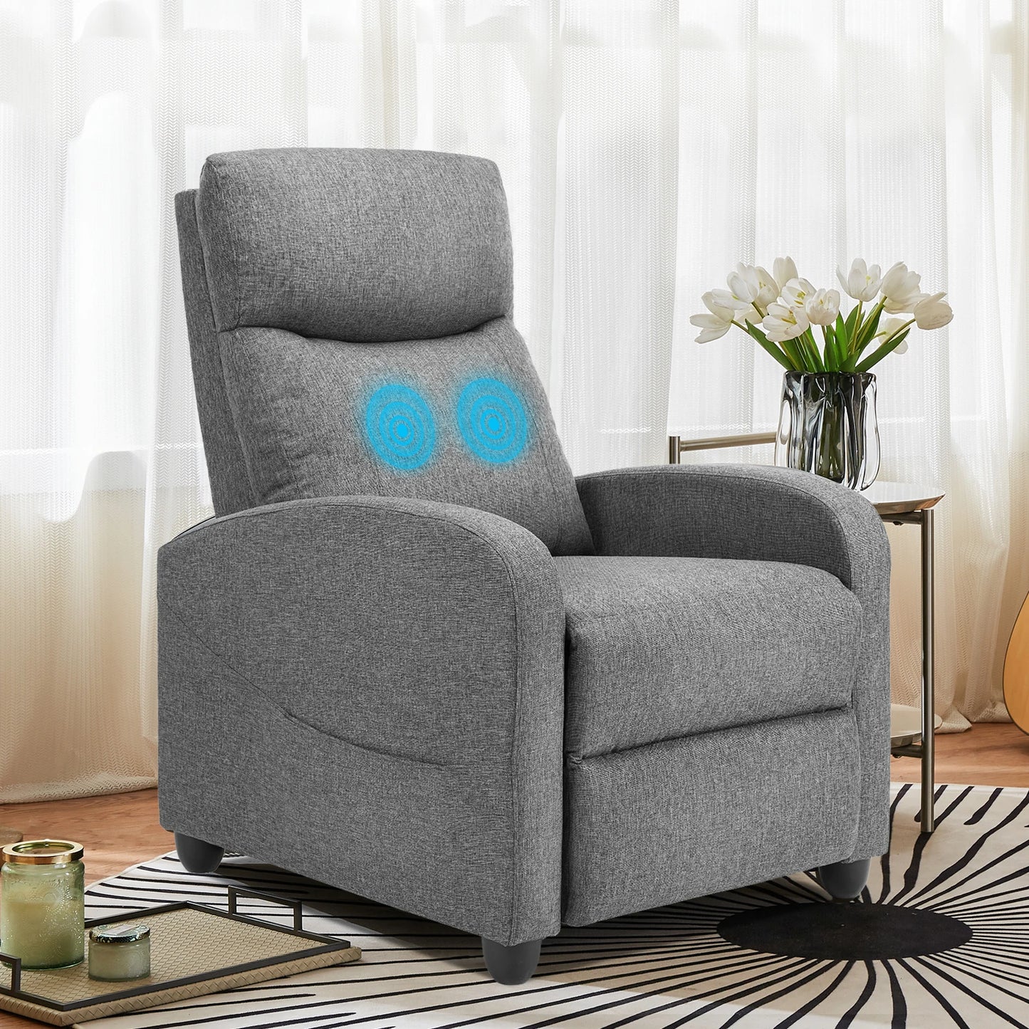 Gray recliner chair with blue circles on a striped rug in a living room setting.