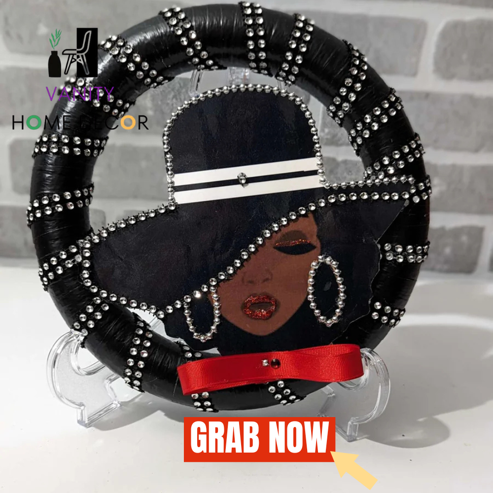 Decorative Lady Black Wreath with a stylized face design on a stand, featuring black hair, red ribbon, and silver embellishments.