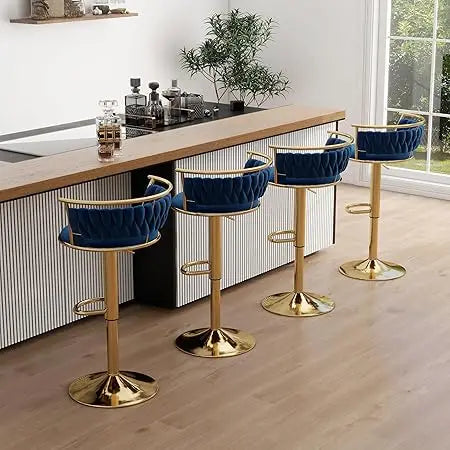 Four blue bar stools with gold bases in a modern kitchen setting.