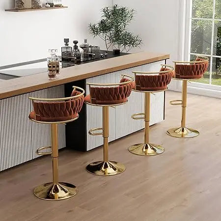 Four brown bar stools with gold bases in a modern kitchen setting.