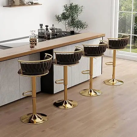 Four black and gold bar stools in a modern kitchen setting.