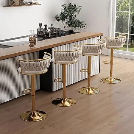 Four modern bar stools with gold bases in a kitchen setting.