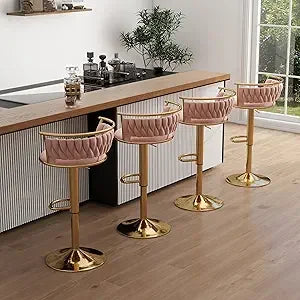 Four pink bar stools with gold bases in a kitchen setting.